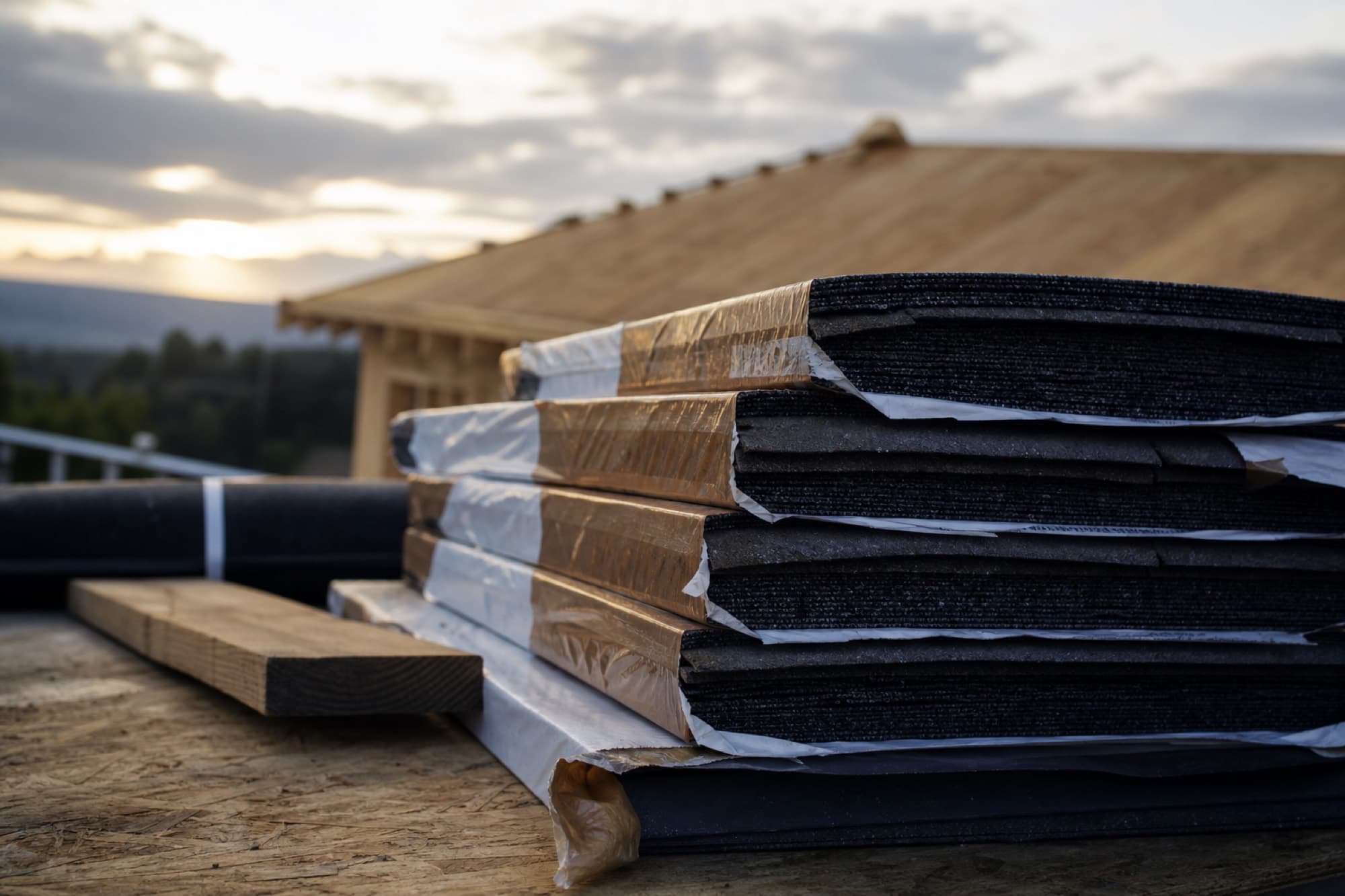 Roofing materials and asphalt shingles staged on a job site